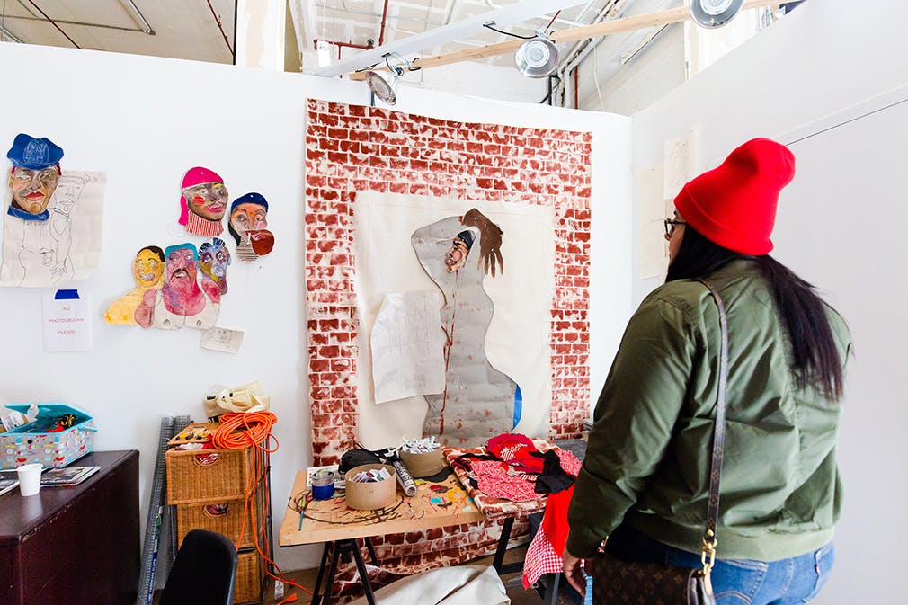 A visitor looking at Tschabalala Self's artwork during the Museum's open studios, Photo: Liz Ligon