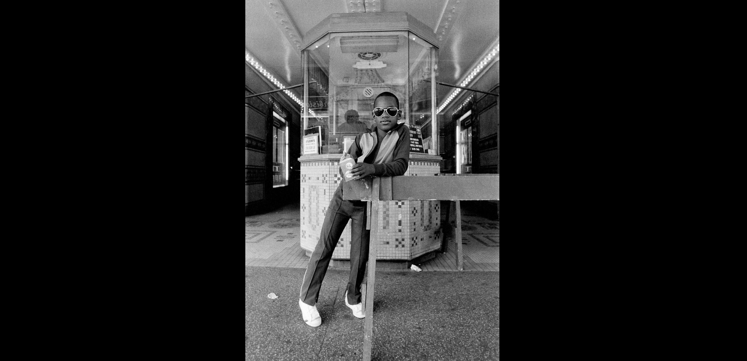 <p>Dawoud Bey, <em>A Boy in Front of the Loews 125th Street Movie Theater</em> (from the series "Harlem U.S.A."), 1976. Silver print, 8 1/2 × 5 3/16 in. Studio Museum in Harlem; gift of the artist 1979.1.12 © Dawoud Bey</p>
<p></p>
<p></p>
